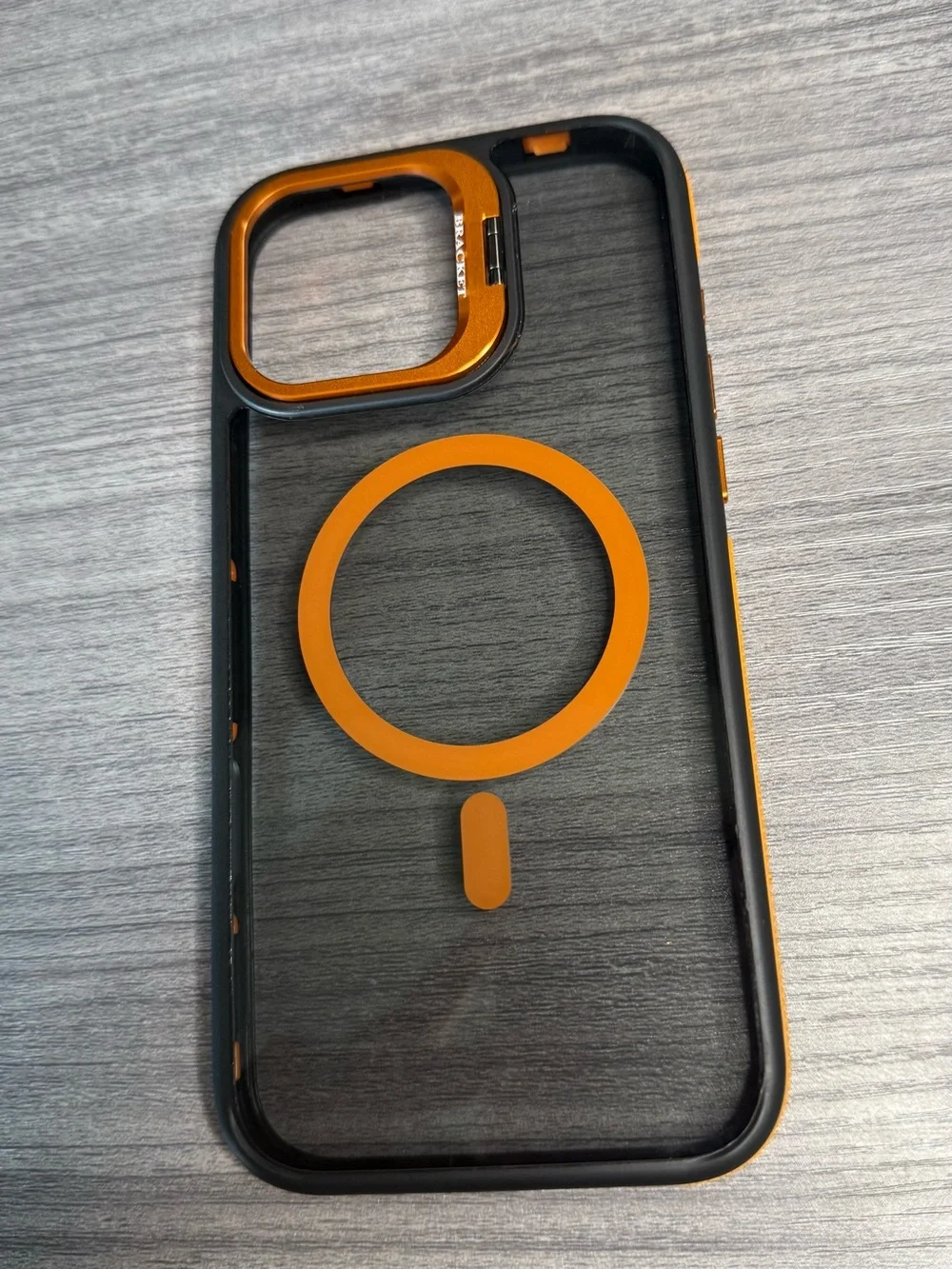 Transparent iPhone 16 Pro Max case, orange and black, MagSafe compatible.